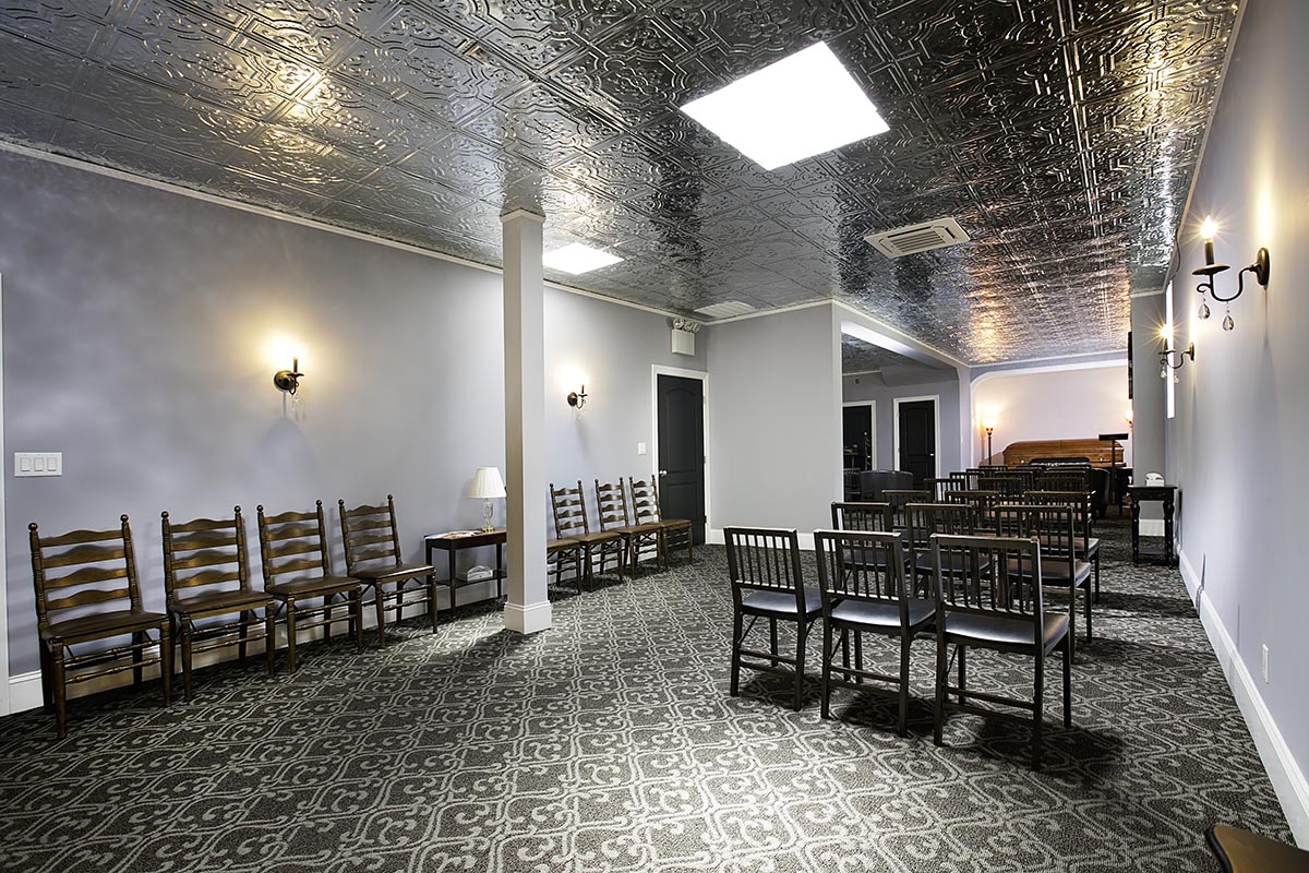 San Jose Funeral Home Chapel with casket in the back & rows of chairs